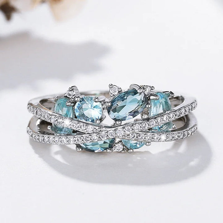 Bague avec croix et pierre précieuse bleue | Or blanc